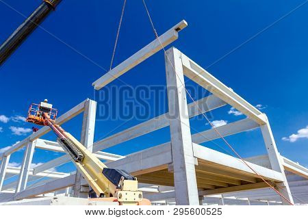 Mobile Crane Is Operating And Worker Is Assembly Concrete Joist In High Place. Height Worker Is Plac