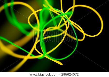 Yellow Neon And Green Neon Abstract. Neon Lines. Isolated On Black Background.