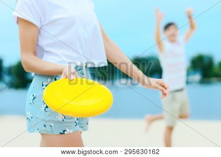 Young Smiling Woman In Light Clothes Is Holding White Racket And Ball In Her Hands. Cheerful Female 