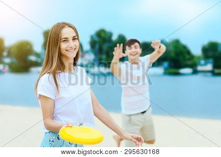 Young Smiling Woman In Light Clothes Is Holding White Racket And Ball In Her Hands. Cheerful Female 