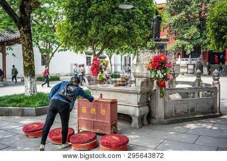 25 April 2018, Wuhan China : Chinese Woman Offering Money To A Goddess Statue At Guiyuan Buddhist Te