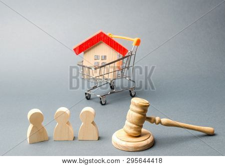 Wooden Figures Of People, A House In A Supermarket Trolley And A Judge's Hammer. Auction. Public Sal