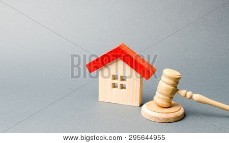 Miniature Wooden House And Judge's Hammer. The Concept Of Resolving Property Disputes. Property Alie
