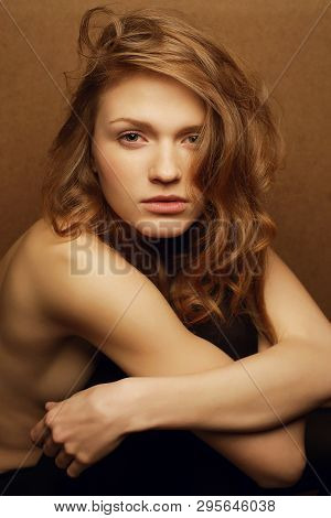 Emotive Portrait Of Young Beautiful Red-haired Girl Over Wooden Background. Studio Shot