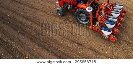 Aerial View Of Tractor With Mounted Seeder Performing Direct Seeding Of Crops On Plowed Agricultural