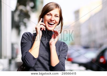 Happy young lady talking on mobile phone