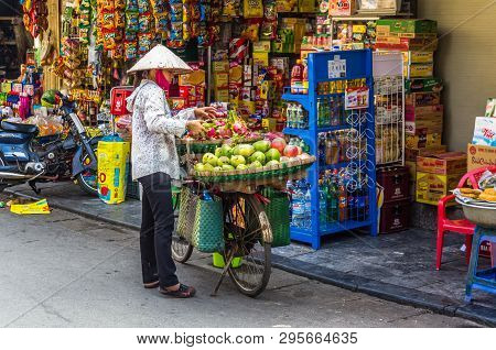 Vietnamise Saleswoman With Bike And Fruits