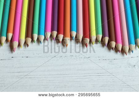 Colored Pencil Border On A Wooden Background, With Copy Space