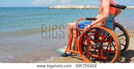 Summer Vacations Of A Young Boy On The Wheelchair On The Sandy Beach By The Sea