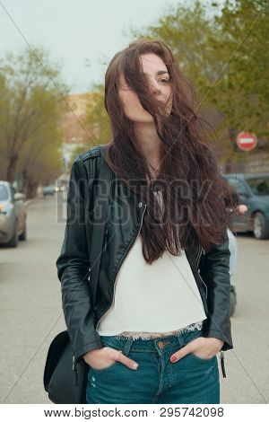 Girl Posing In Windy Day In Jeans And Black Leaser Jacket