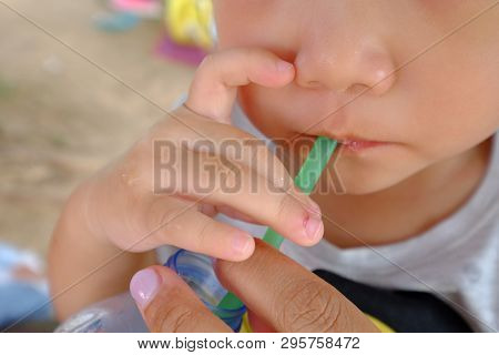 Lower Part Of Asian Baby Face, Drinking Water From Green Plastic Straw