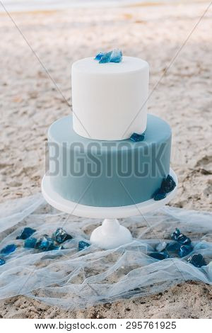 Blue Two-tiered Wedding Cake With On A Beach For A Wedding