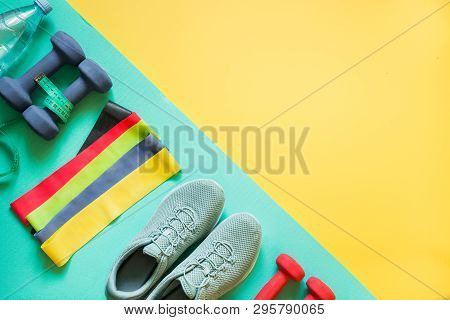 Sport And Fitness Equipment, Dumbbells, Fitness Shoes, Measuring Tape On Punchy Yellow.
