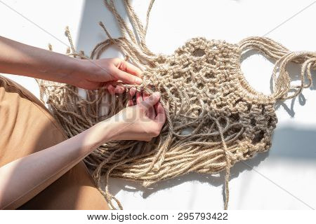 Making A Diy Hemp Bag, Top View. Woman Hands Knitting An Acessory Out Of Natural Jute Rope, Close-up