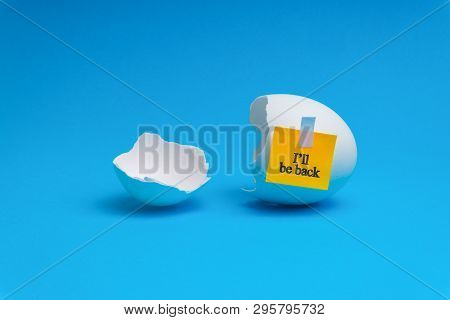 I Will Be Back Words Written On Broken Eggs Shell Over Blue Background. Selective Focus