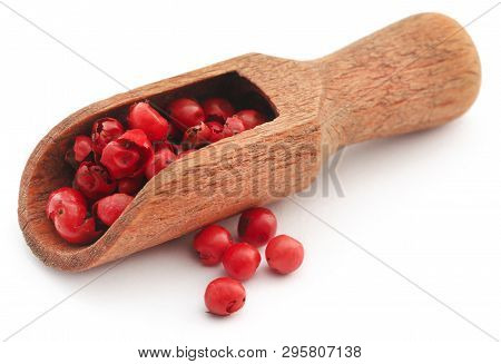 Pink Peppercorn In A Wooden Scoop Over Whtie Background