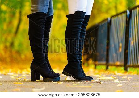 Two Unrecognizable Women Wearing Long Black Heeled Knee High Boots And Jeans. Autumn Fashion, Warm F