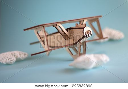 Wooden Plane With Clouds In The Shape Of A Heart On A Blue Background