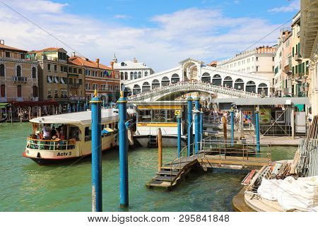 Venice, Italy - June 18, 2018: Rialto Bridge Over Grand Canal In Venice With Traghetto Ferry Stopped