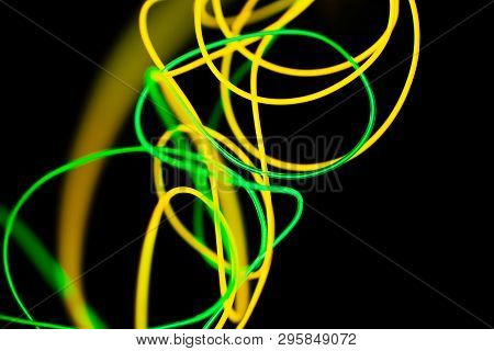 Yellow Neon And Green Neon Abstract. Neon Lines. Isolated On Black Background.