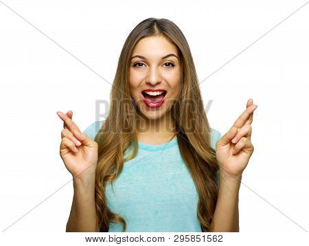 Indoor Shot Of Glad Happy Young Woman Wears T-shirt Smiles Broadly, Keeps Fingers Crossed, Hopes For
