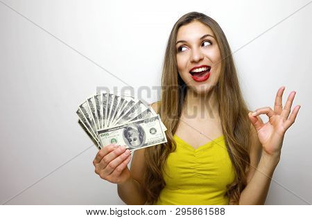 Woman Holding Cash Notes Isolated Over White Background. Young Woman In Big Winning Pose Looking To 