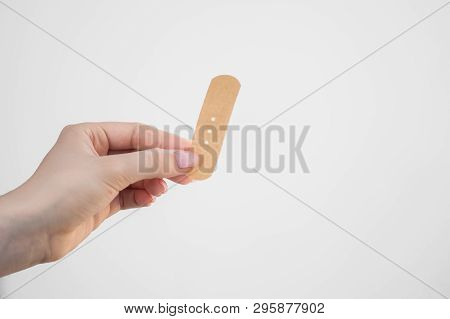 Adhesive Plaster In Hand On A White Background, Adhesive Plaster For First Aid, Female Fingers