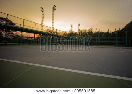 Selective Focus On The Baseline Of Tennis Court With Sunset Sky Background. Landscape Of Sport Place
