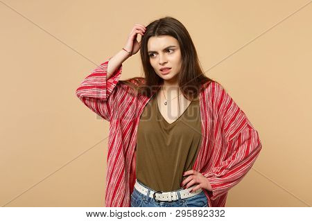 Portrait Of Preoccupied Young Woman In Casual Clothes Looking Aside, Putting Hand On Head Isolated O