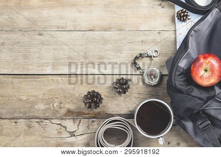 Hiking Backpack, Compass, Belt And Other Camping Gear On A Wooden Background. The Concept Of Hiking 