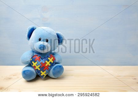 World Autism Awareness Day, Concept With Teddy Bear Holding Puzzle Or Jigsaw Pattern On Heart