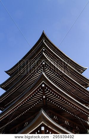 Low Angle View Of Japanese Shrine Pagoda Multi-level Roofs On Blue Sky Background. Conceptual Meanin