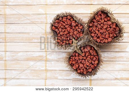 Annatto Seeds On Rustic Wood
