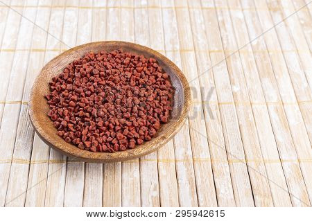 Annatto Seeds On Rustic Wood