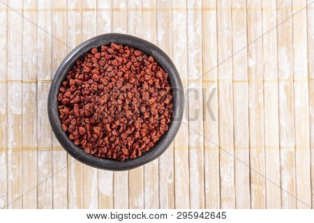 Annatto Seeds On Rustic Wood