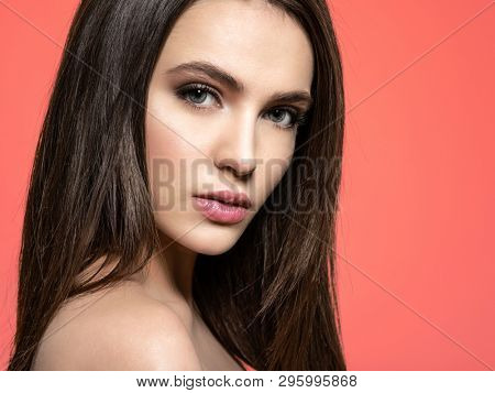 Woman with beauty long brown hair. Fashion model with long straight hair. Fashion model posing at studio.Pretty woman with long straight brown hair looking at camera. Pantone 2019.