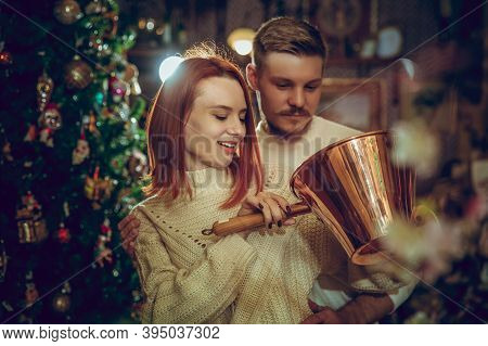Golden. Smiling Family, Caucasian Couple Looking For Home Decoration And Holidays Gifts In Household
