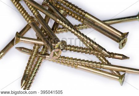 Pile Of Countersunk Wood Screws With Yellow Corrosion Coating, Close-up In Selective Focus