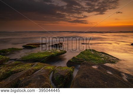 Calm Ocean Long Exposure. Stones Covered By Geen Moss In Mysterious Mist Of The Sea Waves. Concept O