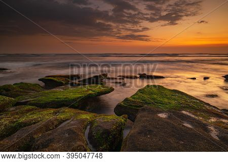 Calm Ocean Long Exposure. Stones Covered By Geen Moss In Mysterious Mist Of The Sea Waves. Concept O