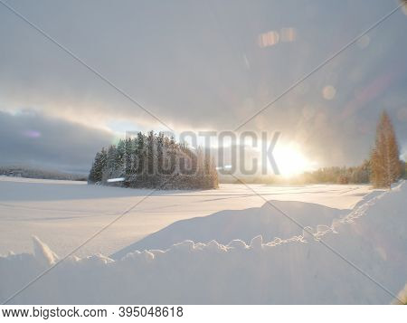 Sunburst Over A Frozen Lake In Finland