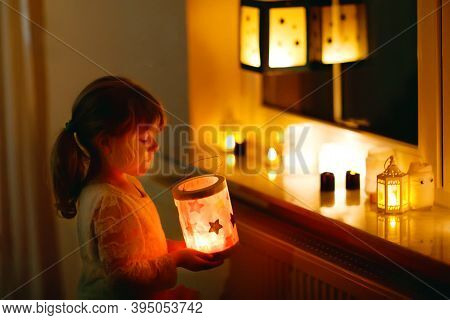 Little Kid Girl Sitting By Window With Selfmade Hand Crafted Lanterns With Candles For St. Martin Pr