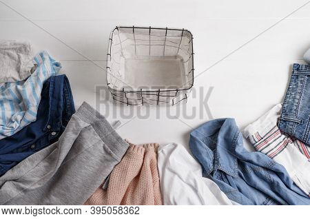 A Group Of Organic Cotton Clothing Set On A White Table Is Ready To Be Folded Into White Baskets.the