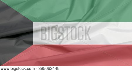Fabric Flag Of Kuwait. Crease Of Kuwaiti Flag Background, Green White And Red Color With Black Trape