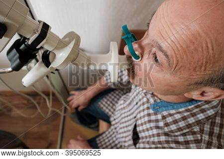 Senior Man Testing Breathing Function By Spirometry