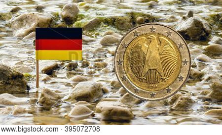 Two Euro Coin Against Fresh Flowing Water Of The Stream With German Flag,business Concept