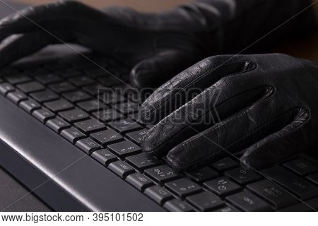 Cybercriminal Hands In Gloves On Laptop Keyboard
