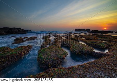 Amazing Seascape. Ocean With Moving Wave. Low Lide. Stones Covered By Green Moss And Seaweeds. Sun O
