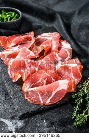Italian Rolled Bacon Pancetta Piacentina. Pork Meat. Black Background. Top View
