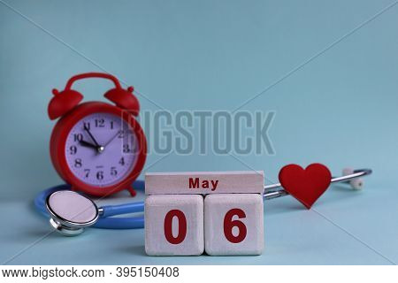 6st May. White Wooden Calendar Blocks With Date, Clock And Stethoscope On A Blue Pastel Background. 